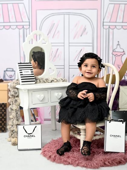 A moment of reflection for our little fashion icon. Sitting in front of her vanity, she looks perfectly poised in her chic black dress during her shopping-themed shoot.