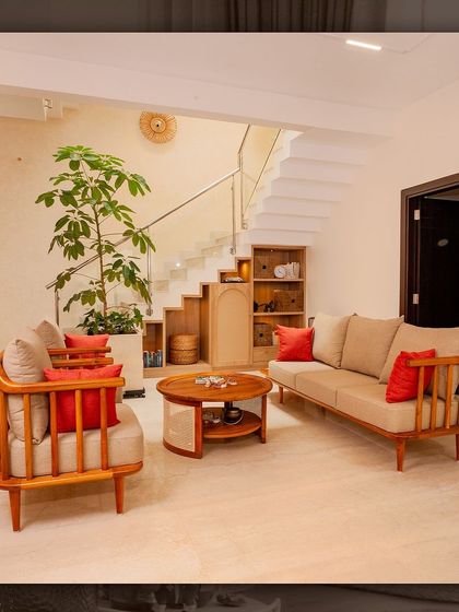 The living room in our NVT Stopping by the Woods project, featuring a custom-made wooden sofa set with clean lines and a large indoor plant to bring nature inside.
