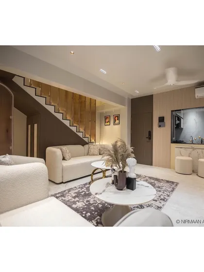 This view of the Duplex Project living room showcases the dramatic, lit staircase that serves as a central design feature, connecting the two levels of the home.
