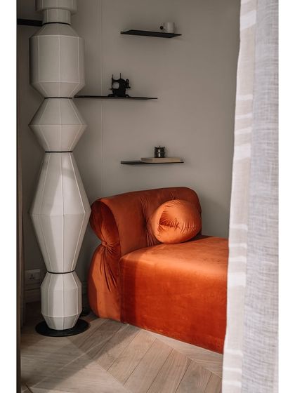 Another view of the master bedroom, showing the sculptural floor lamp and the minimalist shelving. Every piece is chosen to contribute to the room's overall sense of tranquility.