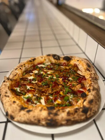 Another look at our Adobo Chicken pizza, with its beautiful charred crust and generous toppings.