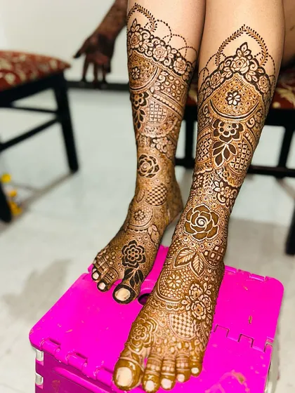 A full view of a heavy bridal leg design. The patterns are intricate and the coverage extends well above the ankle.