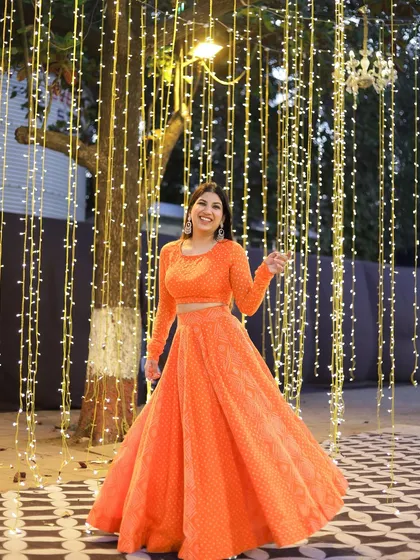 Twirling in my vibrant orange lehenga. I believe in dressing for the occasion and bringing a festive look to every celebration I host.