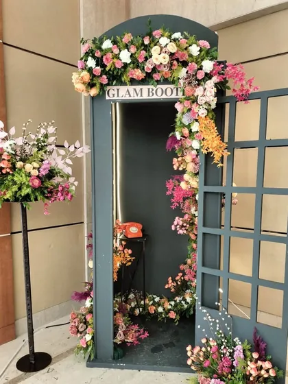 A closer look at the floral arrangement on the "Glam Booth." The mix of pink, white, and orange flowers cascades down the side, making it an elegant and whimsical prop for any event.