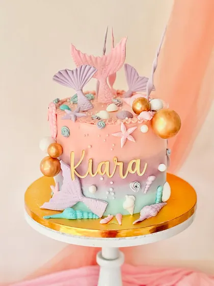 This mermaid-themed cake captures the magic of the ocean. I used a colourful gradient buttercream technique and decorated it with handcrafted fondant seashells, starfish, mermaid tails, and a personalized nameplate for Kiara.