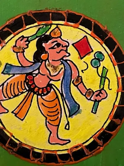 A hand-painted Ganjifa art coaster depicting a dynamic folk figure. Learning to create these small, detailed pieces is a great exercise in precision and storytelling.