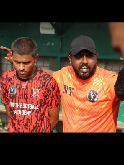 A coach giving instructions to a player during a break in play. Clear communication and tactical adjustments are vital at the competitive level.