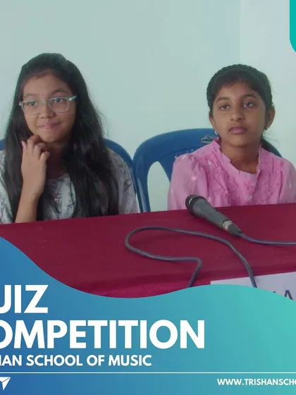 Two students focused at their table during the quiz competition.