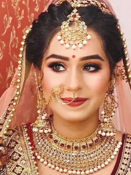 A classic bridal portrait. This look features defined brows, a subtle smokey eye, and a timeless red lip, creating a look of pure elegance for her special day.