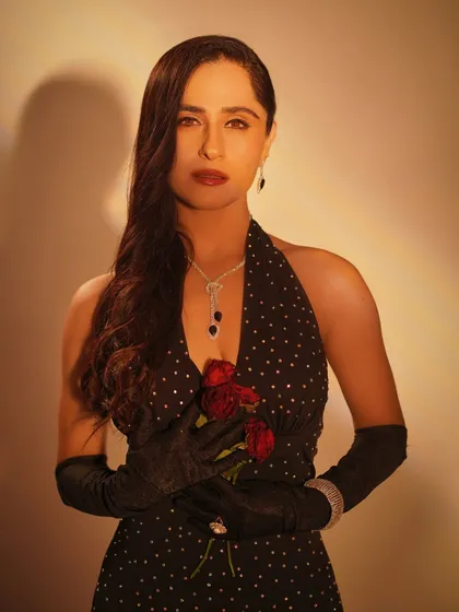 A classic portrait with a vintage feel. The soft lighting and the way she holds the roses create a sense of old-world Hollywood glamour, complemented by deep red lips and side-swept waves.