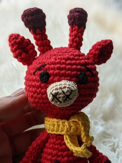 A bright red giraffe with a yellow scarf, showing how colors can be customized.