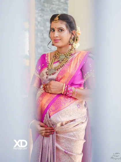 A bright and happy portrait of the mother-to-be, framed by a doorway, looking radiant during her baby shower celebration.