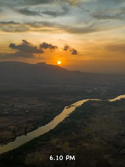 The sun is a perfect golden orb at 6:10 PM, hanging in the sky over the hazy landscape.