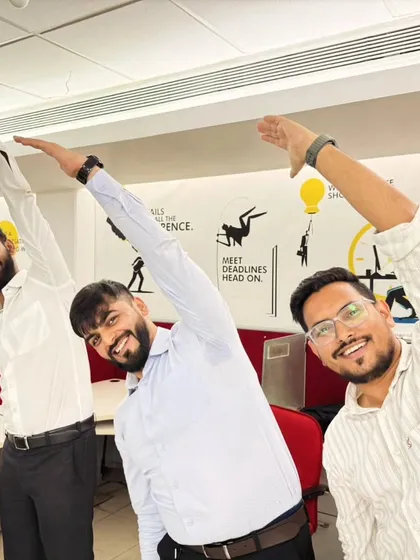 Office workers taking a moment to do a simple side-body stretch. These chair yoga exercises are perfect for releasing tension in the back and shoulders from prolonged sitting.