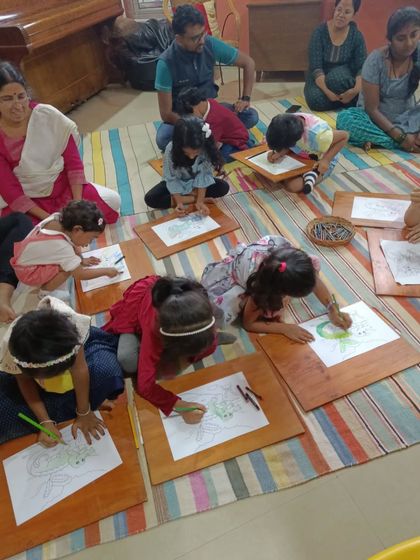 A different angle of the coloring session, showing how absorbed the children are in their work.