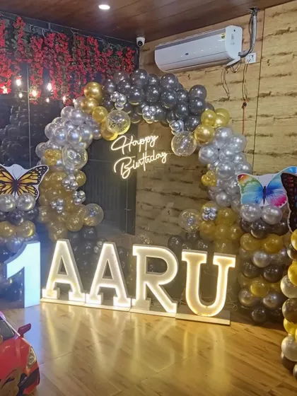 A beautiful butterfly-themed decoration for Aaru's first birthday. I used a black, gold, and silver color palette with large butterfly accents and illuminated letters.
