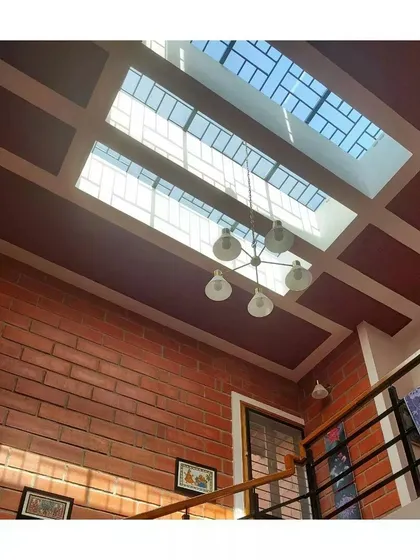 A large skylight floods a double-height space with natural light, reducing the need for artificial lighting and highlighting the texture of the brick wall.