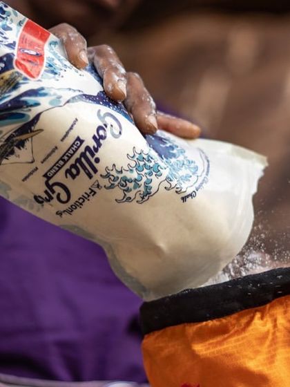 We love using quality chalk to ensure good grip on sweaty days. Here, a climber refills her chalk bag before tackling a route.