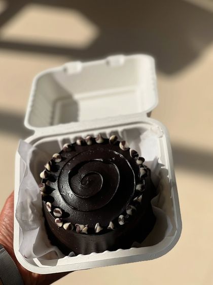 A simple but elegant chocolate bento cake with a beautiful ganache swirl and chocolate chip details.