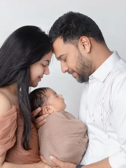A beautiful and intimate pose for new parents, creating a circle of love around their newborn baby.