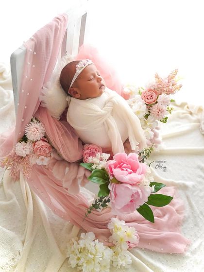 This wider angle shows the full, romantic setup with draping fabrics and an abundance of flowers, creating a truly enchanting scene.