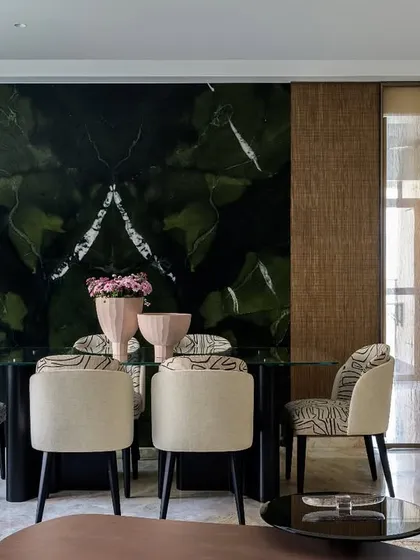This dining space features a seamless flow into the kitchen, framed by a sliding door. The backdrop of rich green avocado quartz makes a powerful statement, creating a space where elegance and harmony are served with every meal.