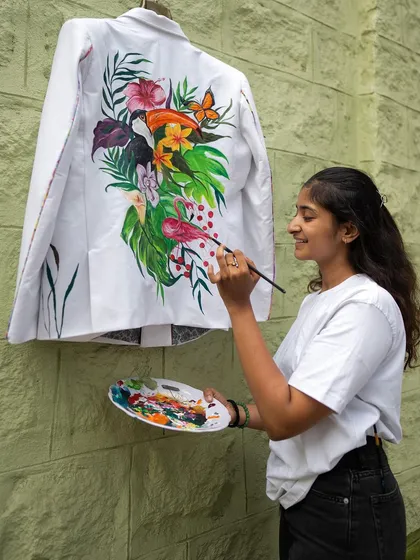Here I am in my element, bringing a plain white blazer to life. Every piece I create is a conversation between the fabric, the paint, and my heart. This forest-themed jacket features toucans, flamingos, and lush florals, all painted with love.