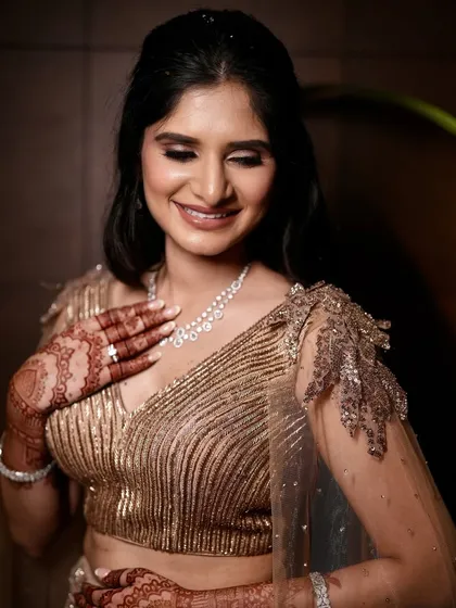 A candid, happy moment from the engagement. Her golden-toned makeup looks radiant and joyful, perfectly capturing her smile.