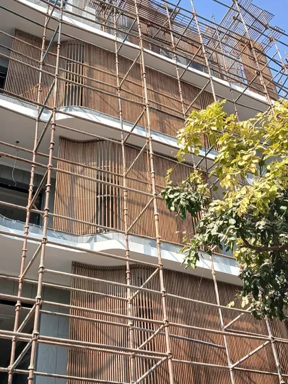 This site photo shows the intricate wooden screens being installed. The design creates an intervention of openness and striking architectural elements that will define the home's character.
