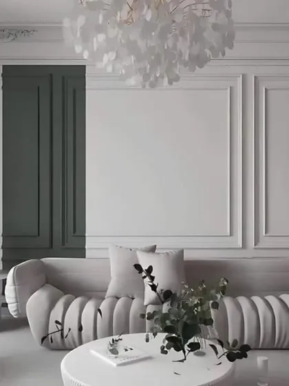 A concept image showing a living room with classic wall molding and a modern, curved sofa. The contrast between the dark green panel and the white walls adds a dramatic flair.