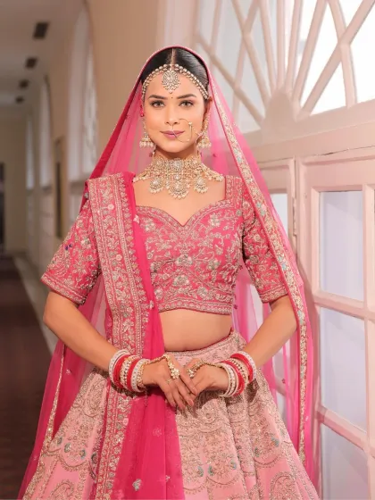 A full-length shot of the bride in her dreamy pink pastel lehenga. The makeup is designed to be soft and romantic, completing her fairytale look.
