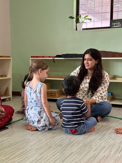 Our co-founder sits with two young students during a workshop in Bandra, creating a moment of personal connection and gentle guidance.