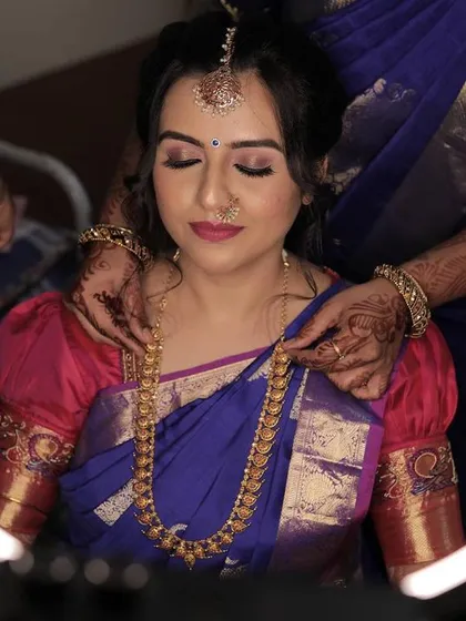 Chinmayi's varpooje look was absolutely captivating. We went for a dramatic smokey eye and a soft pink lip to complement her royal blue and pink Kanjeevaram saree.