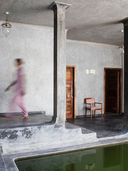 A moment of movement along the corridor of the main villa, which wraps around a central lily pond. The design uses simple, powerful forms and materials like polished concrete to create a sense of calm and timelessness.