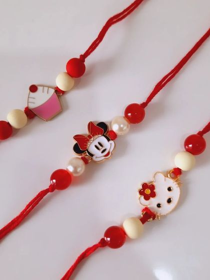 So much cuteness in one picture. These handmade Rakhis feature Hello Kitty and Minnie Mouse charms on a simple red and white beaded thread, perfect for your little sister or brother.