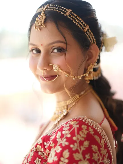 A smiling portrait of the Pahadi bride, showcasing her natural-looking makeup and traditional nose ring.