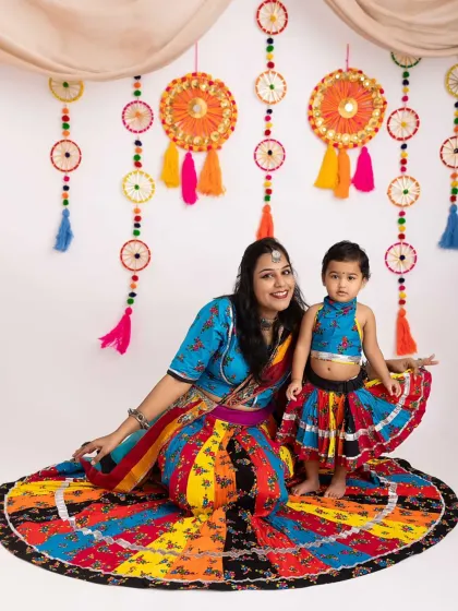 A beautiful mother-daughter portrait celebrating Navratri. The way their colorful skirts fan out creates such a stunning and memorable image.