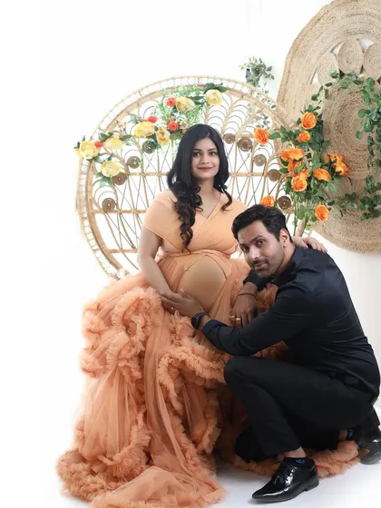 A beautiful family portrait in the making. The dad-to-be kneels to embrace the baby bump, creating a memory of shared excitement and love.