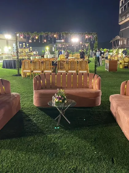 I also create comfortable lounge areas for guests to relax and network. This setup features stylish pink velvet sofas with gold accents, providing a chic and comfortable seating option at the outdoor venue.