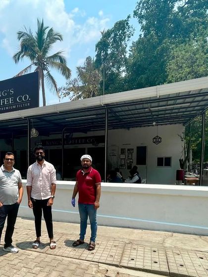 The Sparkleminds team stands with the founders outside a modern King's Coffee Co. outlet. This demonstrates the brand's evolution and our role in preparing them for the next stage of growth.