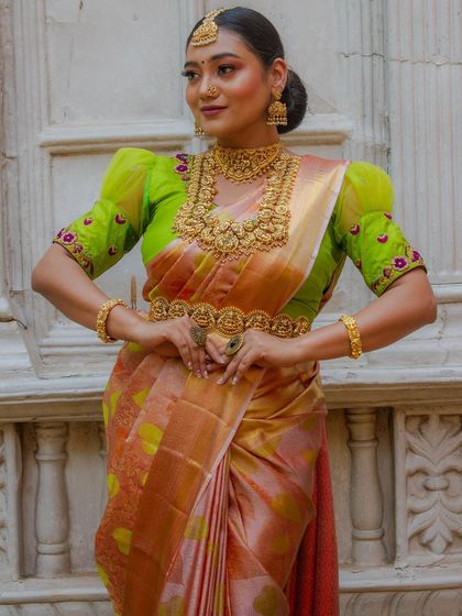 A close-up of the model, showing the intricate Vaddanam and layered necklaces.