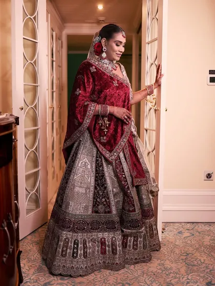 A full-length shot of the bride in a grand corridor, looking like she stepped out of a palace.