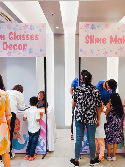 Activity stalls for a mermaid-themed party, offering sunglasses decorating and slime making. I always tailor the activities to fit the party's theme.