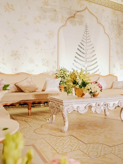 A soft, dreamy shot of the lounge area, focusing on the elegant furniture and floral arrangements. The overall effect is one of timeless grace and comfort.