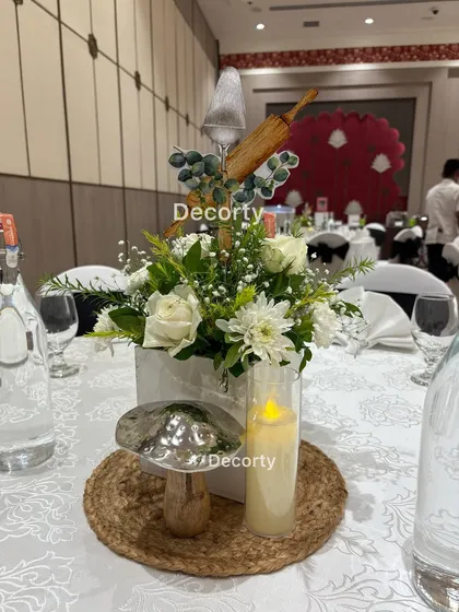 Even the table centerpieces are part of the theme. This arrangement features fresh white flowers mixed with fun, custom cutouts of a rolling pin and spatula, all centered around an elegant LED candle.