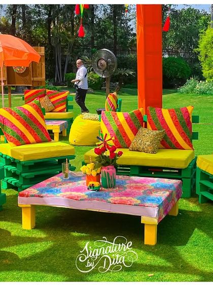 I used brightly painted pallet furniture with colorful striped cushions to create casual and fun seating areas for the Holi party, perfect for a relaxed outdoor gathering.