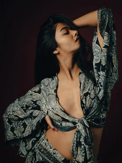 A powerful and sensual pose that highlights the model's form and the flowing fabric of the outfit.