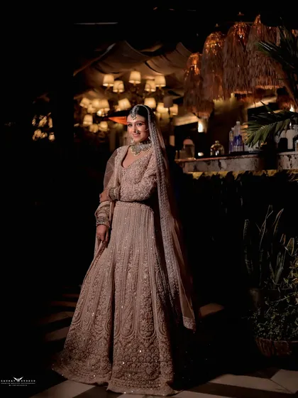 A dramatic, wide-angle shot of the bride in a beautifully lit venue, creating a grand and cinematic feel.