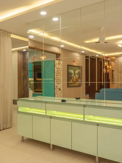 This image shows a crockery unit we executed, featuring back-painted glass shutters and internal lighting. The mirrored wall behind it was also part of our scope, installed to make the dining space feel larger.