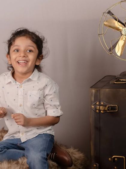 A bright, happy, and candid shot from a simple studio portrait session. We focus on capturing the genuine smiles that light up a child's face.